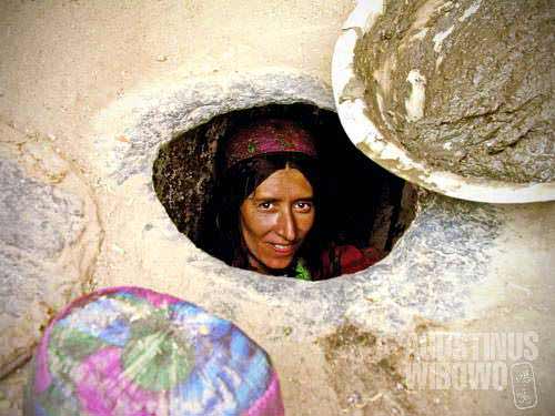 A woman making a tandoor, the traditional oven to prepare bread