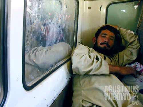 A man is lying when traveling in a truck, in the mountainous province of Ghour. In the Central Route of Afghanistan, transport is main problem for villagers, and people have to hitchhike on trading trucks to travel around the area.