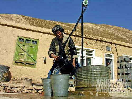 A Hazara farmer from Dahne Karqol gets water from a communal well in the village.
