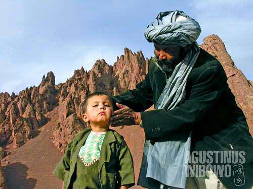 A Hazara man directing his son to pose in front of the camera on the top of Shahtu Pass, Yakawlang, Bamiyan. Shahtu is among the incredible mountain passes in Afghanistan, 70 percent of which area are mountainous.