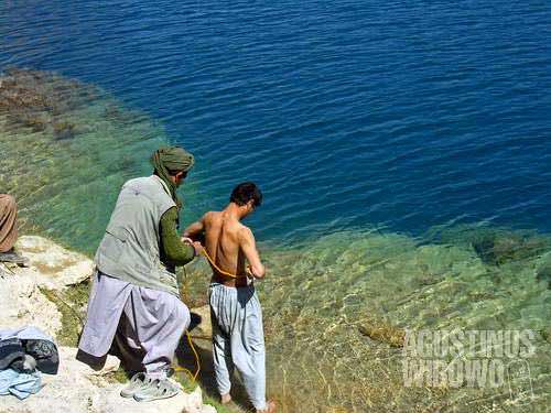 A Shiite pilgrim is dipping into the cold water of Band-e-Haibat, the holiest among 6 lakes of Band-e-Amir. The Shiites believe that the miraculous Band-e-Amir were created by their Imam, Hazrat Ali, and dipping into the water is believed to heal all sicknesses.