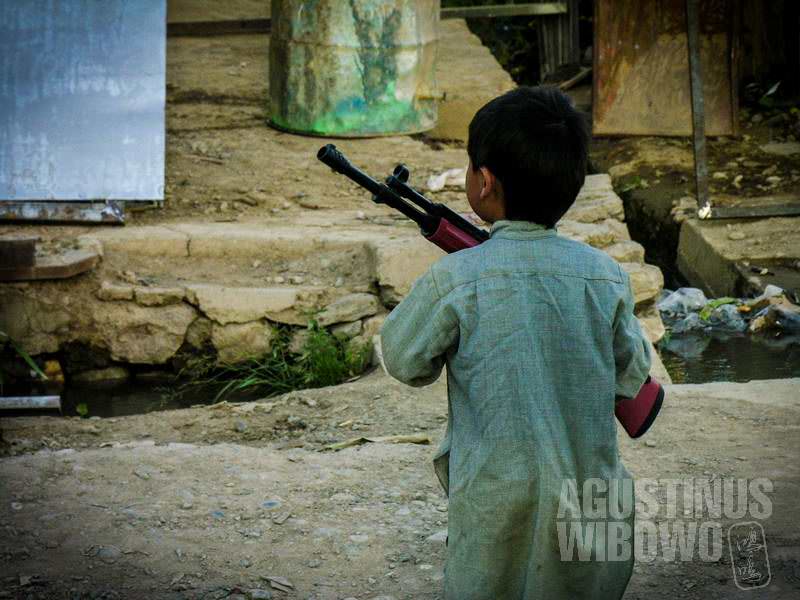 Bocah kecil Bamiyan dengan mainan bedil plastik. (AGUSTINUS WIBOWO)